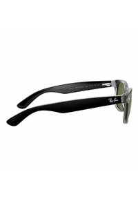 Gli occhiali da sole Ray-Ban Wayfarer presentano lenti grigie, montatura frontale trasparente e aste nere opache con una superficie liscia. Logo stampato sull'asta.