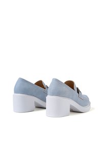 Scarpe in suede azzurro chiaro con punta rotonda e tacco bianco spesso. Presentano una fascia decorativa e una superficie liscia.