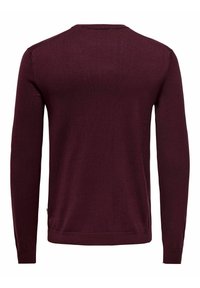 Maglione lungo bordeaux realizzato in morbido tessuto a maglia. Presenta un collo rotondo e polsini e orlo a coste. Tessuto liscio, senza motivi.