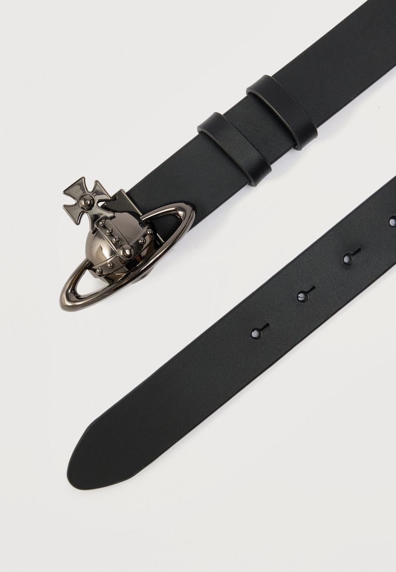 Cintura in pelle nera con una grande fibbia metallica a forma di pianeta con una croce e un anello, dotata di più fori per la regolazione.