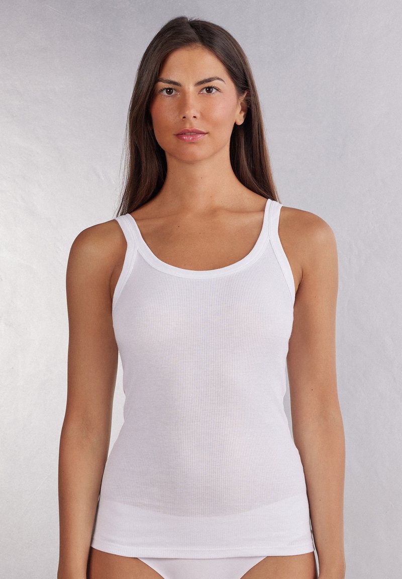 Witte geribde tanktop met brede bandjes, zachte textuur en een aansluitend ontwerp. Het heeft een ronde halslijn en een rechte zoom.