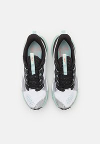 Black and white athletic shoes with a mesh upper, mint green accents, padded collar, and patterned sole, featuring a black lace-up design.