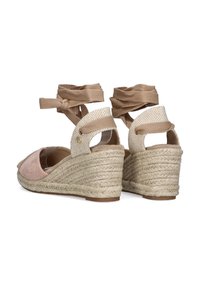 Sandalias de cuña con suela de yute tejido color beige, puntera de ante rosa claro y correas de tela beige en el tobillo. Presenta cortes y detalle de herraje circular.