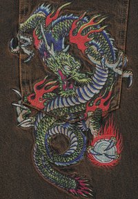 Tejido de mezclilla negra con un vibrante diseño bordado de un dragón verde con acentos azules y llamas rojas, destacando texturas detalladas.