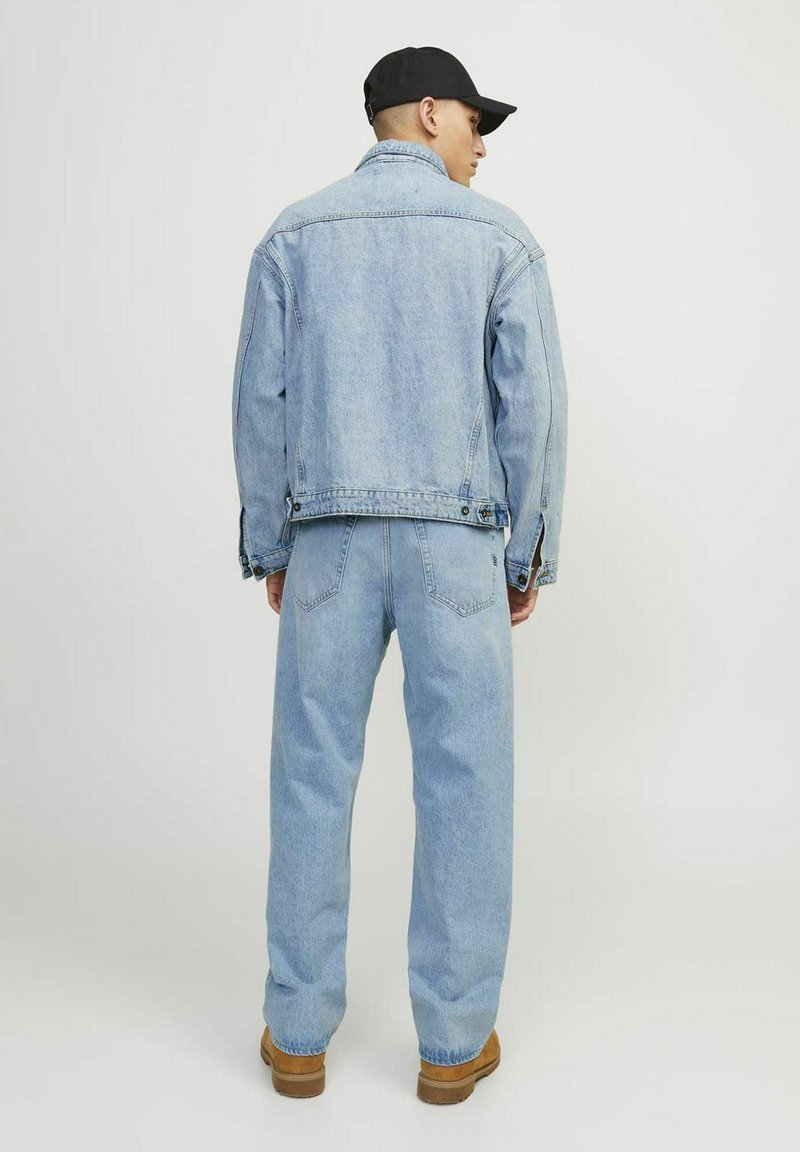 Chaqueta de denim y jeans a juego en azul claro. La chaqueta presenta un cuello clásico y cierre de botones; los jeans tienen un ajuste relajado y costuras resistentes.