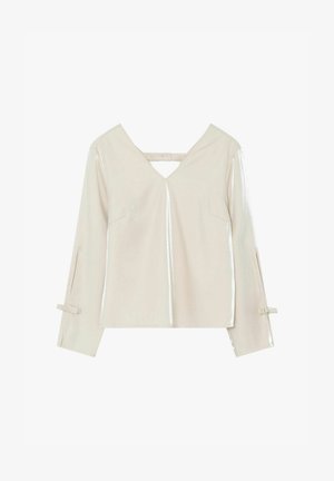 Pikkade varrukatega kreemjas pluus V-kaelusega, selja rihmade detailiga, kerge läikega kangas ja väikesed kaared varruka mansettidel puhtal taustal.