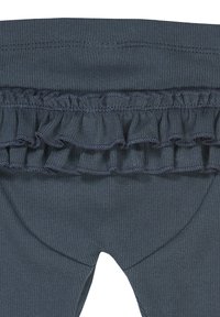 Tummansinisiä legginssejä, joissa on volaanimallinen vyötärö. Kangas on ribbikuvioista, ja ommeltu yksityiskohta korostaa volaania.