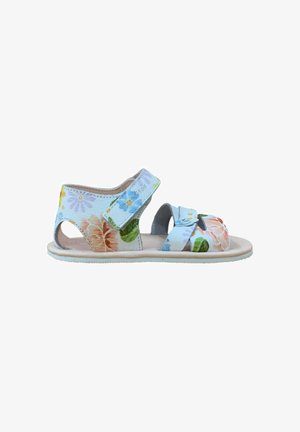 Sandalia infantil de punta abierta con patrón floral azul, correas ajustables sobre el tobillo y los dedos, y suela suave beige.
