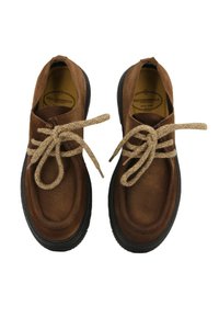 Scarpe in suede marrone con punta arrotondata, superficie testurizzata e lacci beige annodati. Suole in gomma nera a contrasto. Design neutro.