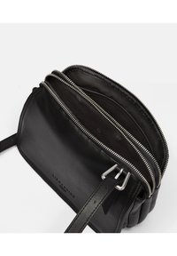 Borsa a tracolla nera in pelle con due scomparti con zip, hardware argentato, tracolla regolabile e superficie texturizzata. Interno foderato.