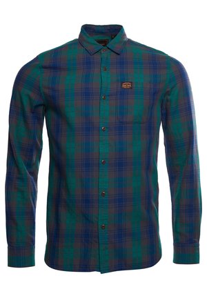 Męska koszula na długi rękaw z zielono-niebieską kratą i małą kieszonką na piersi z brązową etykietą.
