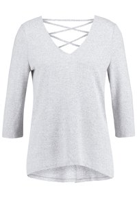 Grå stickad topp med djup V-ringning och korsade band, trekvartsärmar och asymmetrisk nederkant. Mjuk textur med en avslappnad design.