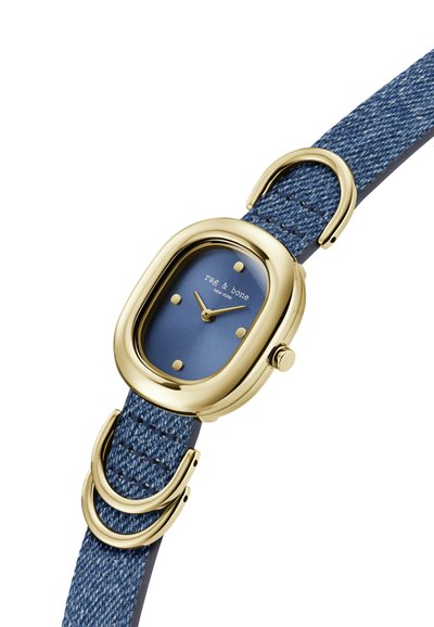 Arany színű óra téglalap alakú számlappal, kék számlappal és denimszerű kék szíjjal, amely arany gyűrűkkel van díszítve.