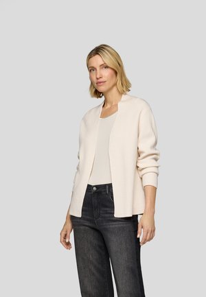 Light beige cardigan with a ribbed texture, open front design, and long sleeves; paired with gray high-waisted jeans.
