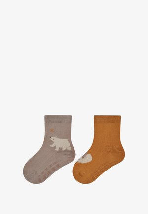 Kindersocken: eine beigefarbene mit einem Eisbär-Motiv und einem braunen Stern, die andere in Orange mit einem weißen Bären, beide mit rutschfesten Sohlen.