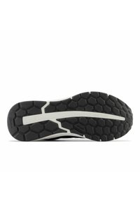 Svart atletisk sula med hexagonalt mönster, vit mellansula accent och texturerade greppytor. Innehåller märkningen "WALKING STRIKE PATH".