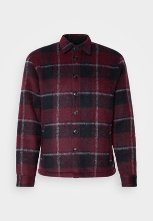 Giacca a quadri rossa e nera realizzata in tessuto morbido, con chiusura a bottoni e design con colletto. Superficie texturizzata con accenti grigi.