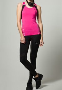 Rosa atletisk tanktopp med svarta detaljer och reflexdetaljer, kombinerad med svarta leggings med texturerade paneler och svarta sportskor.