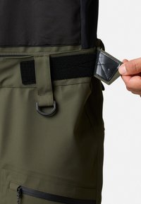 Olijfgroene duurzame broek met een gestructureerde zwarte tailleband, verstelbare riem en een zijvak met rits. Voorzien van een metalen lusdetail.