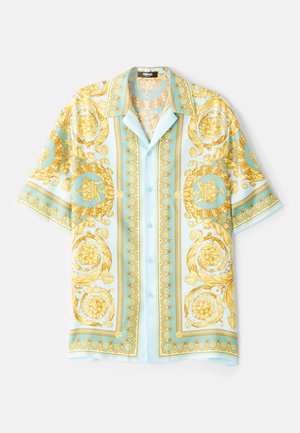 Chemise à manches courtes bleu clair ornée de motifs baroques dorés, avec un boutonnage à l'avant et une coupe décontractée. Tissu lisse avec une texture brillante.
