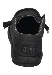 Schwarze Leinen-Slipper mit strukturierten Oberflächen, ausgestattet mit einem gemusterten Innenfutter, elastischen Schnürsenkeln und einem Logopatch an der Ferse.