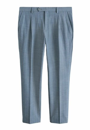 Männerhand neben blau gestreifter Hose mit einer Ein-Knopf-Gesäßtasche, beiger Oberteil teilweise sichtbar.