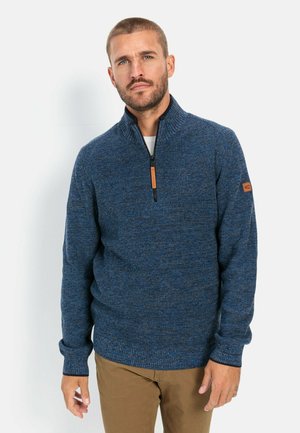 Navy blue zip-up sweater with a textured knit design, featuring a high collar and brown leather accent near the shoulder.