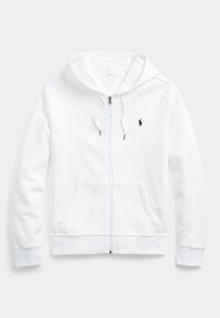 Vit zip-up hoodie tillverkad av mjukt material. Har en huva, två framfickor och en liten svart logotyp på vänster bröst.