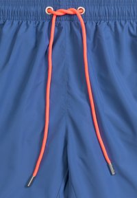 Niebieskie szorty kąpielowe z elastycznym paskiem w talii, zdobione jaskrawopomarańczowym sznurkiem ściągającym z metalowymi końcówkami w kolorze srebrnym. Gładka faktura i lekki materiał.