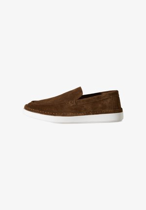 Brauner Slip-on-Loafer aus Wildleder mit weißer Gummisohle, sichtbarer Naht und flachem Design auf weißem Hintergrund.