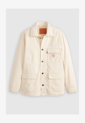 Jachetă de culoare crem, confecționată din bumbac, cu guler răspândit, închidere frontală cu nasturi, două buzunare mari și o mică etichetă cu logo pe piept.