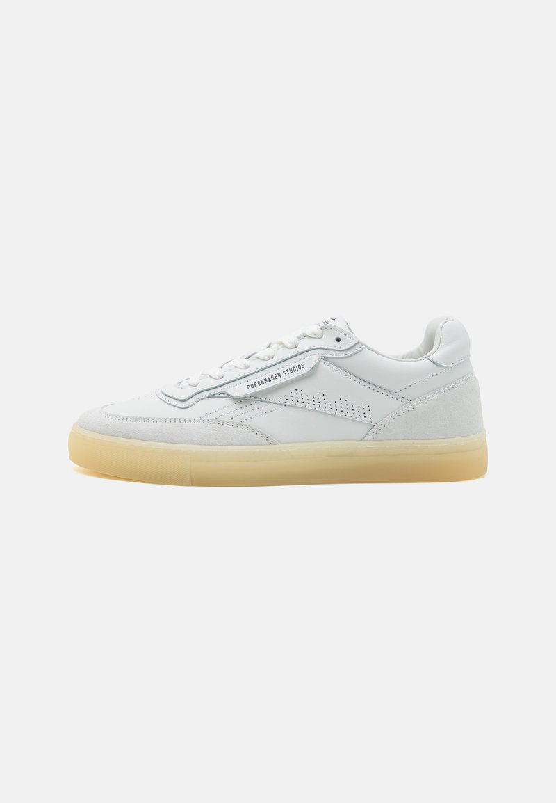 Sneaker bianche in pelle con una texture liscia, dettagli a perforazione, e suola in gomma naturale. Presentano lacci bianchi e etichetta del marchio sul lato.
