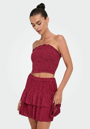Ensemble bordeaux à deux pièces avec un haut ajusté sans bretelles orné de volants et une jupe mini à étage assortie dotée d'une taille élastique.
