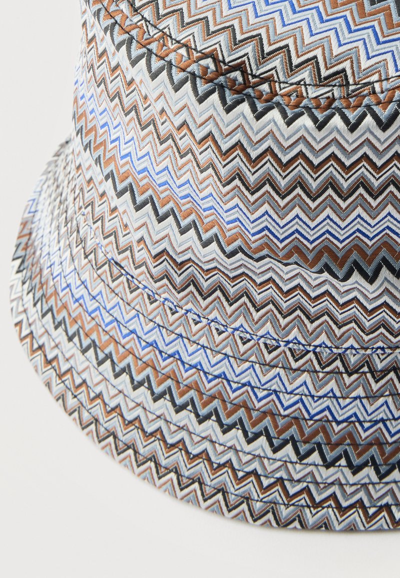 Bucket hat with multicolored zigzag pattern in blue, brown, black, and white, highlighting detailed stitched texture and fabric weave.