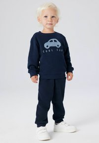 Marineblauer Pullover mit der Aufschrift "COOL CAR" und Autodesign, kombiniert mit passender Hose und weißen Sneakers. Weiches Material und lockere Passform.
