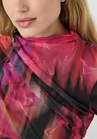 Stof met bloemenpatroon in tinten roze en zwart, met een gedrapeerd ontwerp, een zachte, gestructureerde oppervlakte en een gladde glans.