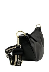 Zwart leren handtas met een gebogen vorm, voorzien van gouden hardware, een ritssluiting en een zwart-witte gestreepte band.