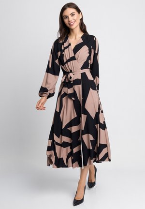 Długa sukienka w formie narzutki, wykonana z miękkiego materiału, z czarno-beżowym abstrakcyjnym wzorem, dekoltem w serek, długimi rękawami i przewiązanym w pasie paskiem.