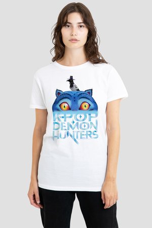 Junge Frau trägt ein weißes T-Shirt mit leuchtend blauen Katzenaugen und einem schwarzen Vogel mit Hut über dem Text "K-Pop Demon Hunters".