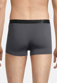 Boxer briefs grigi con una cintura elasticizzata nera. Texture liscia senza motivi o accenti visibili. Lunghezza delle gambe corta.