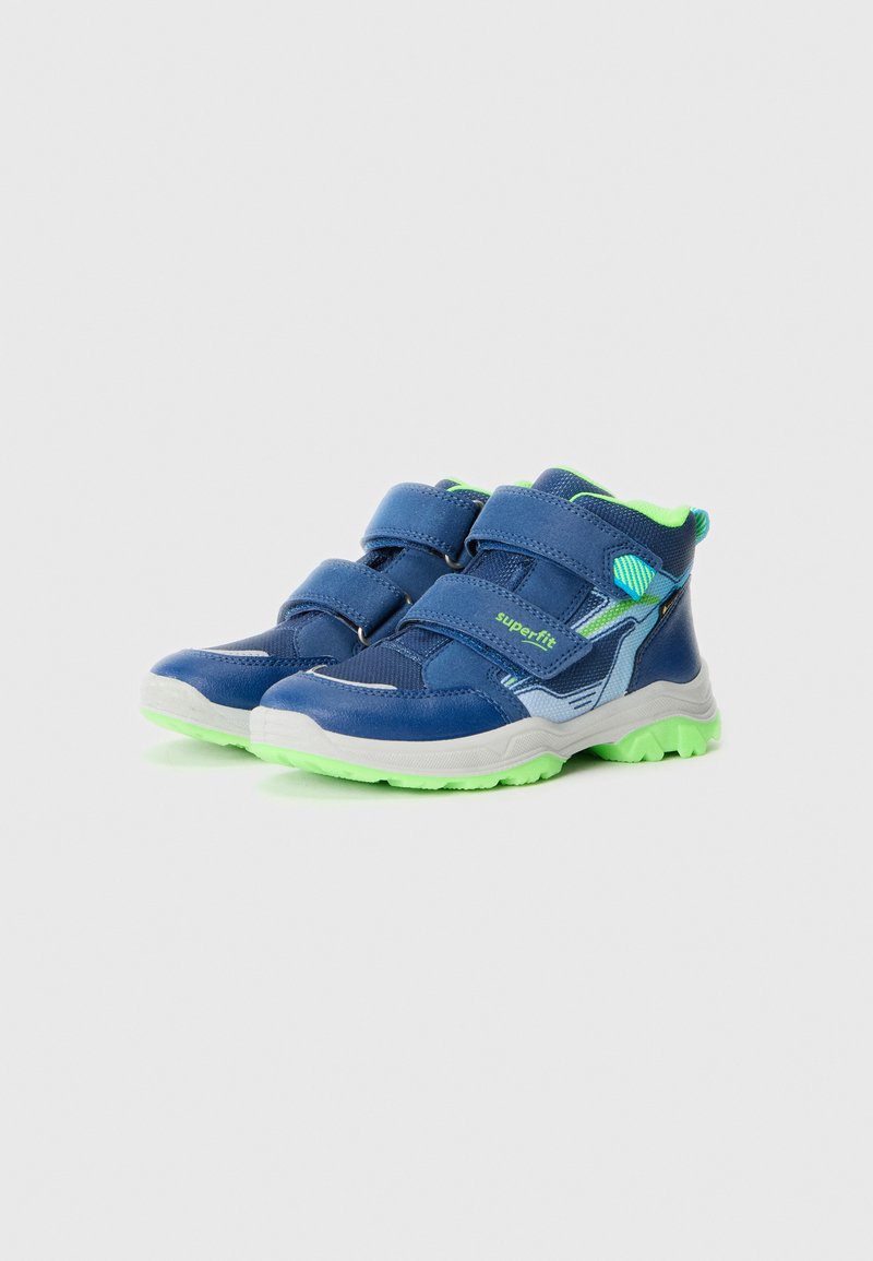 Blaue High-Top-Schuhe mit grünen Akzenten, ausgestattet mit zwei Klettverschlüssen, einer strukturierten Oberfläche und einer dicken, mehrfarbigen Gummisohle.