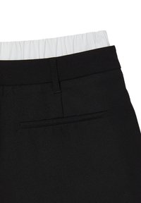 Pantaloni neri con una texture liscia, dotati di una cintura elastica bianca. Include una piccola tasca posteriore discreta.