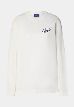 Camiseta blanca de manga larga con cuello redondo y pequeño logo "Gant" en color azul marino en el pecho izquierdo sobre un fondo liso.