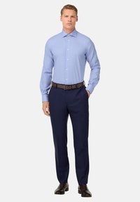 Camicia button-up azzurro chiaro con un motivo testurizzato, maniche lunghe, abbinata a pantaloni navy scuri e cintura e scarpe in pelle marrone.