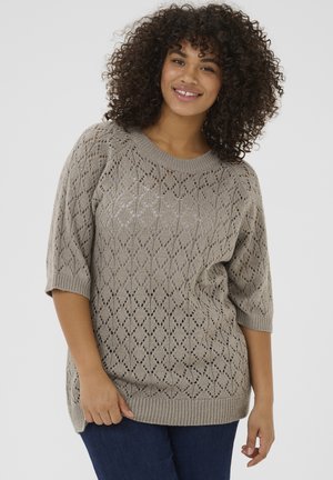 Hellgrauer, gestrickter Pullover mit Rautenmuster, weitem Rundhalsausschnitt und kurzen Ärmeln. Strukturiertes Finish, getragen über dunkelblauen Jeans.