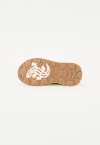 Talpa de sneaker din cauciuc maro, cu modele texturate pentru aderență și un detaliu alb cu logo. Suprafață netedă, concepută pentru tracțiune și durabilitate.