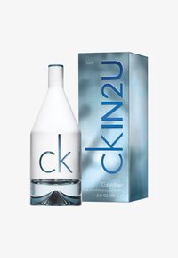 Bouteille en verre transparent de forme triangulaire, logo gravé et accents bleus à côté d'une boîte turquoise avec un texte en gras et une finition métallique.