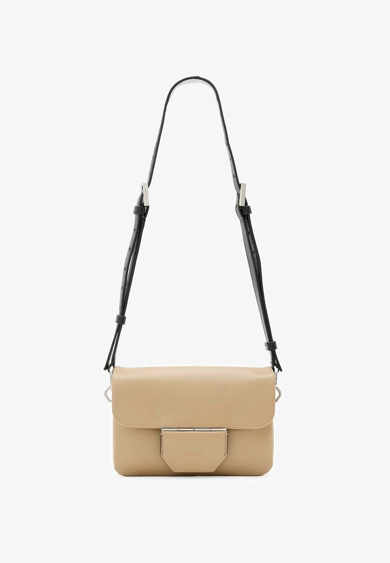 Beige læder crossover taske med klaplukning, sølv hardware og en aftagelig sort rem med justerbare huller.