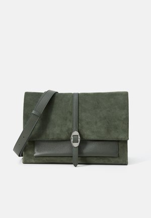 Borsa a tracolla verde in suede con tasca frontale in pelle testurizzata, tracolla regolabile e chiusura in metallo color argento. Design a ribaltina.