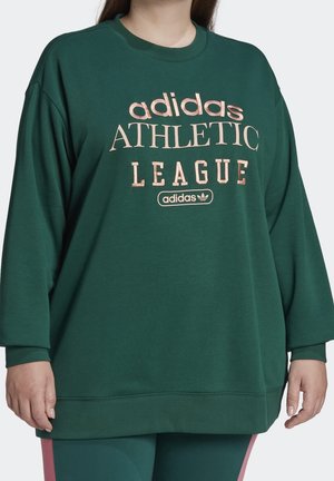 Grøn langærmet sweatshirt med teksten "adidas ATHLETIC LEAGUE" i lyserød, båret med matchende grønne bukser med lyserøde striber.